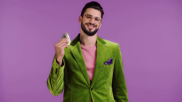 man in velour jacket counting money isolated on purple - Video, Çekim