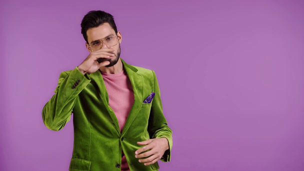 man in velour jacket pointing with finger isolated on purple - Footage, Video