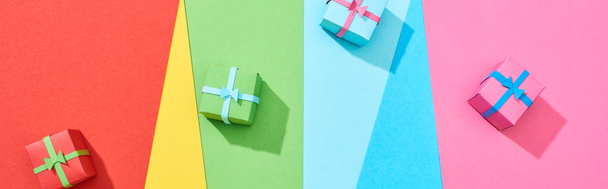 top view of multicolored gift boxes scattered on rainbow background, panoramic shot - Foto, Imagem