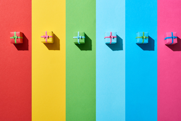 top view of multicolored gift boxes on rainbow background - Φωτογραφία, εικόνα