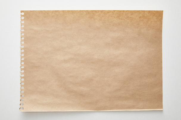 bovenaanzicht van leeg ambachtelijk papier op witte achtergrond - Foto, afbeelding