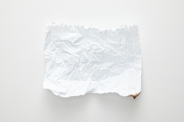 Draufsicht auf leeres zerknülltes Papier auf weißem Hintergrund - Foto, Bild