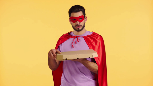 Superhelden öffnen Schachtel mit Pizza isoliert auf gelb - Filmmaterial, Video