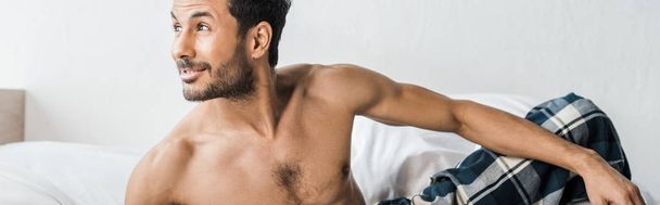 panoramic shot of handsome and sexy bi-racial man smiling and looking away in morning  - Fotografie, Obrázek