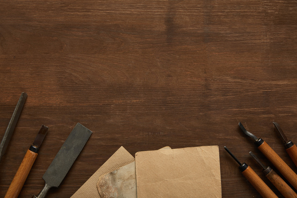 vista superior de herramientas de carpintería envejecidas cerca de papeles antiguos en blanco en mesa de madera
 - Foto, Imagen