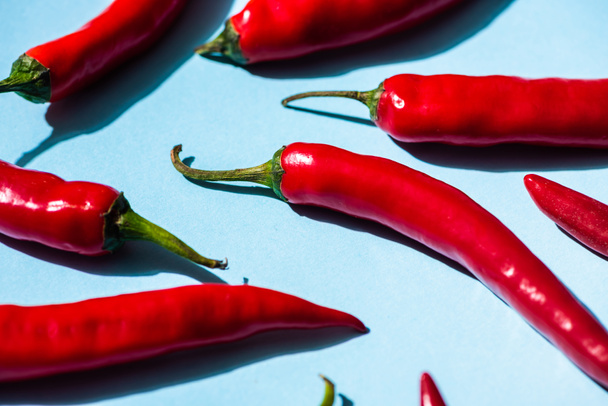 Fresh spicy chili peppers on blue background - Photo, Image