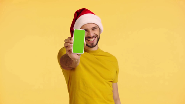 mężczyzna wskazując palcem na smartfon odizolowany na żółto - Materiał filmowy, wideo