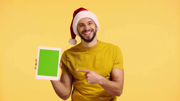 man pointing with finger at digital tablet isolated on yellow - Footage, Video