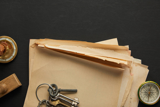 ylhäältä näkymä vintage paperi, avaimet, kompassi ja leima musta tausta
 - Valokuva, kuva