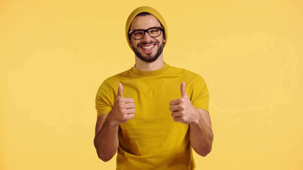 smiling man showing likes isolated on yellow - Footage, Video