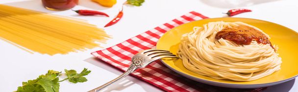 Panoramic shot of tasty spaghetti with tomato sauce beside cilantro on white background - Photo, image