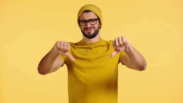 szomorú ember mutatja hüvelykujját le elszigetelt sárga - Felvétel, videó