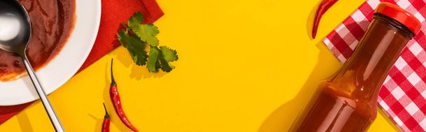 Horní pohled na domácí kečup s chilli paprikou a cilantro na žlutém pozadí, panoramatický záběr - Fotografie, Obrázek
