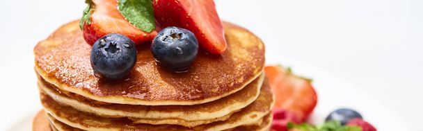Nahaufnahme von leckeren Pfannkuchen mit Honig, Blaubeeren und Erdbeeren, Panoramaaufnahme - Foto, Bild
