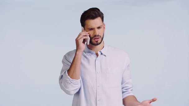 Usmívající se muž mluví na smartphone izolované na modré  - Záběry, video