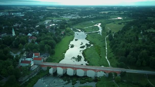Vliegen over de breedste waterval van Europa in Letland Kuldiga en Brick Bridge Aan de overkant van de rivier de Venta in de avond na zonsopkomst. Een echt Dron schot.. - Video