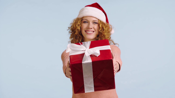 Noel Baba şapkalı mutlu kadın gri renkte izole edilmiş hediye kutusu gösteriyor. - Video, Çekim