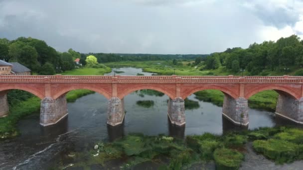 Vliegen over de breedste waterval van Europa in Letland Kuldiga en Brick Bridge In de ochtend na zonsondergang over de rivier de Venta. Een echt Dron schot.. - Video