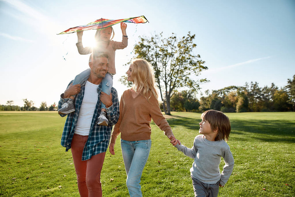 You cannot break this chain. Happy family playing a kite. Outdoor family weekend - Φωτογραφία, εικόνα