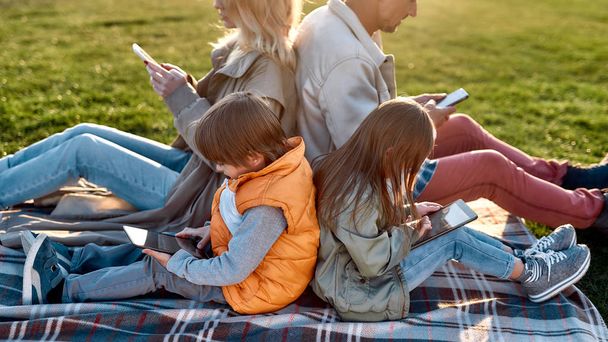 Technologies. Family spending time in the park on a sunny day - 写真・画像