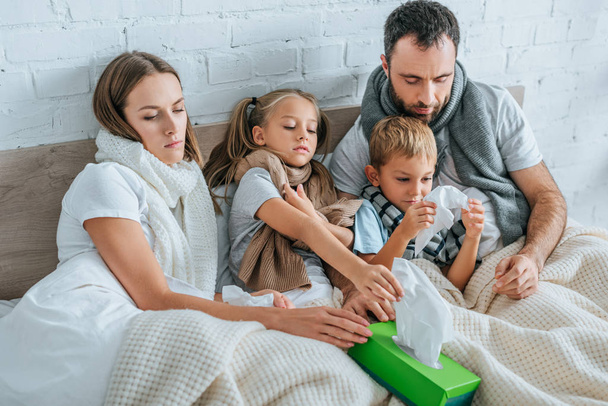 άρρωστοι οικογένεια λαμβάνοντας χαρτοπετσέτες, ενώ βρίσκονται στο κρεβάτι μαζί - Φωτογραφία, εικόνα