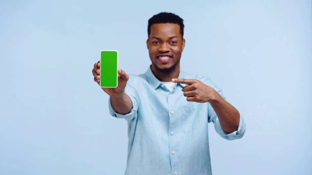 hombre afroamericano feliz mostrando teléfono inteligente aislado en azul
 - Imágenes, Vídeo
