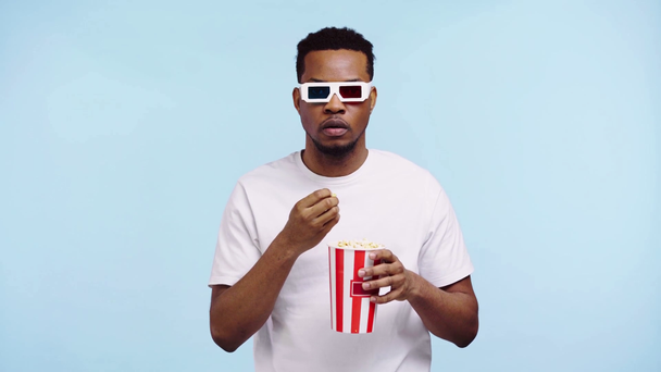 τρομαγμένος Αφροαμερικάνος που βλέπει ταινία απομονωμένη στο μπλε - Πλάνα, βίντεο
