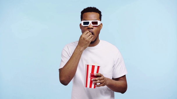 figyelmes afro-amerikai férfi néz film elszigetelt kék - Felvétel, videó