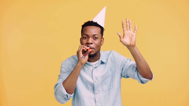 hombre americano africano feliz agitando la mano aislado en amarillo
 - Imágenes, Vídeo