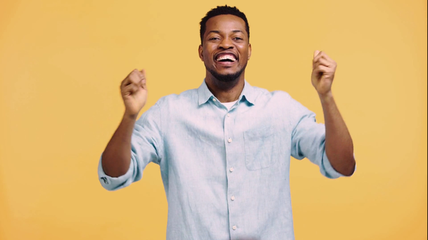 glücklich afrikanisch-amerikanischer Mann beobachtet Basketballspiel isoliert auf gelb - Filmmaterial, Video