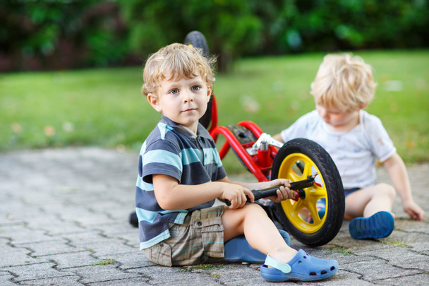 Deux petits garçons, frères et sœurs, réparer le vélo à l'extérieur
. - Photo, image