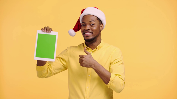 Afrikalı Amerikalı adam sarı tablet üzerinde izole edilmiş dijital tablet gösteriyor. - Video, Çekim