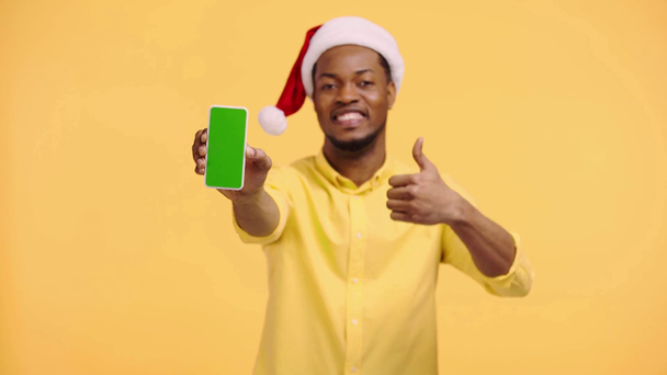 alegre afroamericano hombre mostrando teléfono inteligente aislado en amarillo
 - Imágenes, Vídeo