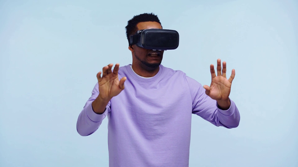 african american man gesturing in vr headset isolated on blue - Materiał filmowy, wideo