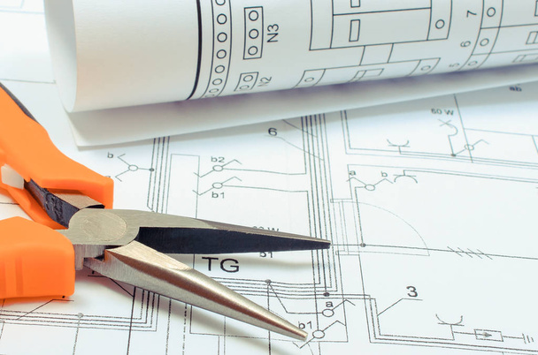 Electrical diagrams and pliers on construction drawing of house. Building home concept - Φωτογραφία, εικόνα