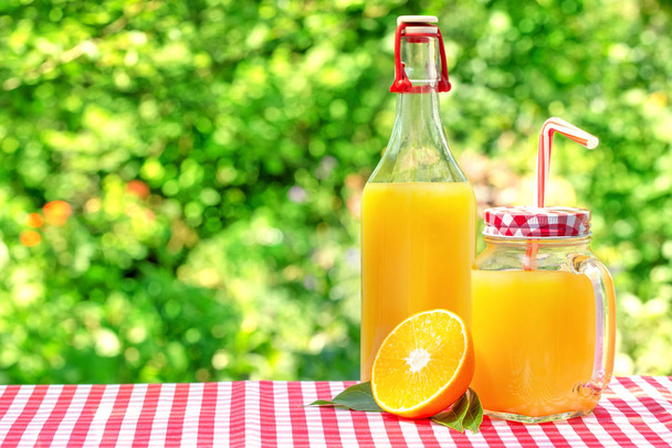 グラス瓶とオレンジジュース付きボトル - 写真・画像