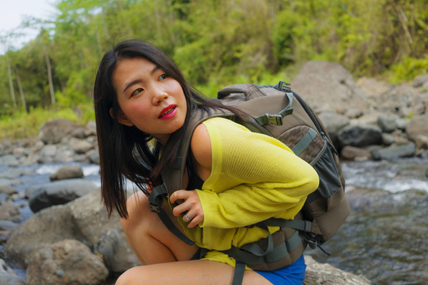 美しい若者と幸せなアジアの女性が川を渡って山の上でバックパックトレッキングを運ぶ休日の自然と新鮮な環境を楽しんで陽気にハイキング  - 写真・画像