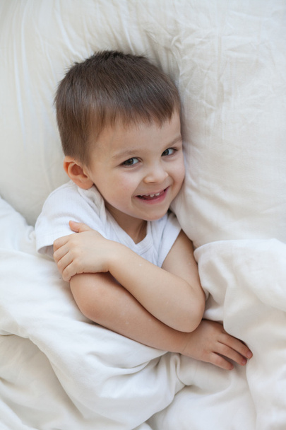 Boy, lying in bed, smiling - Photo, Image