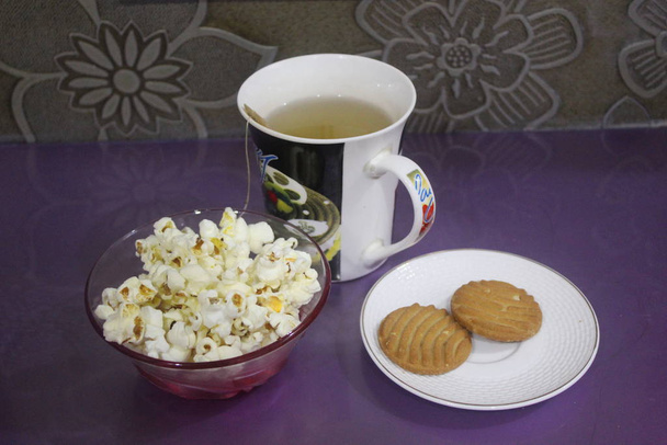 зеленый чай со вкусом лимона и пакетиком чая с печеньем и попкорном
 - Фото, изображение