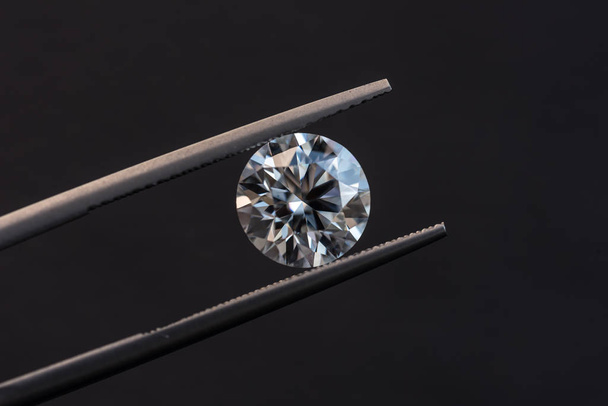 Diamante de forma redonda em pinças de jóias
 - Foto, Imagem