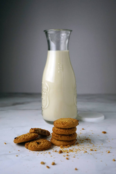 Chocolate chip cookies with milk bottle on table. - Фото, изображение