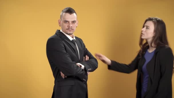 Business people man and woman talking against yellow background - Filmati, video
