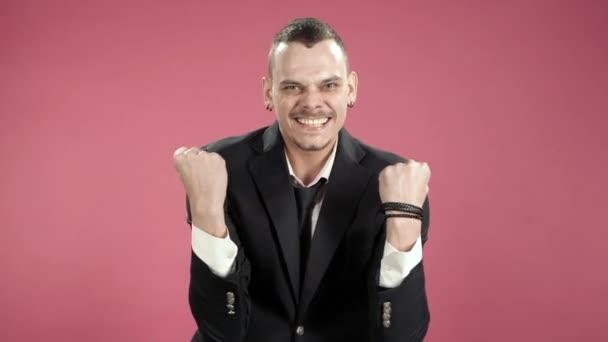 Young man hipster in a suit joyfully showing yes gesture on camera over pink background - Filmmaterial, Video