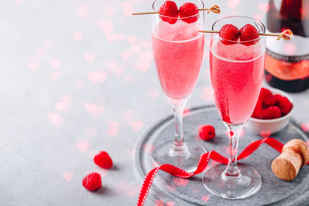 Pink cocktail with champagne or prosecco and fresh raspberries for  Valentine's day.  - Foto, afbeelding