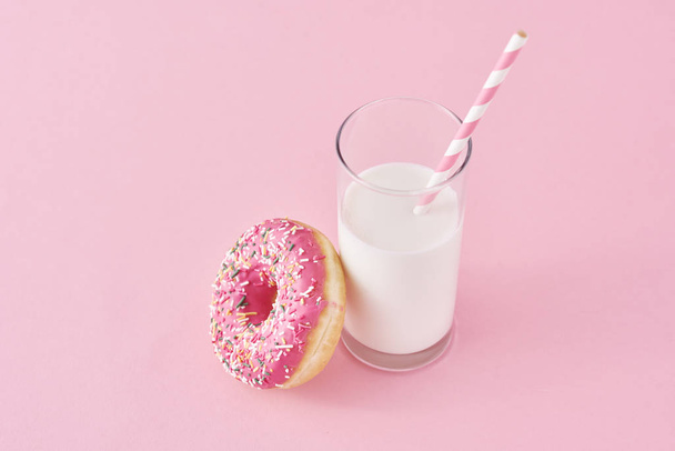 Donuts with glass of milk on a pink background - Foto, afbeelding