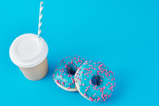 Cup of coffee and donuts on a blue background, top view - Photo, Image