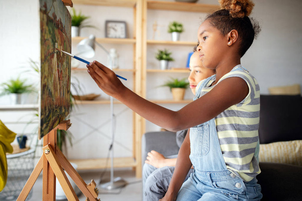 Cute children painting together. Education, art, fun and creativity concept. - Fotó, kép