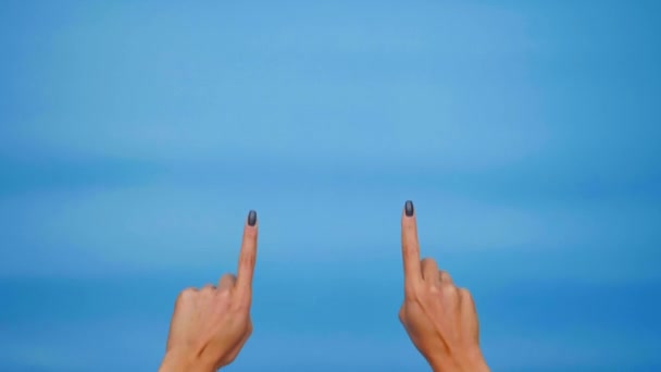 Female hands pointing up on copyspace and showing thumbs up over blue background. 4K slowmotion footage - Footage, Video