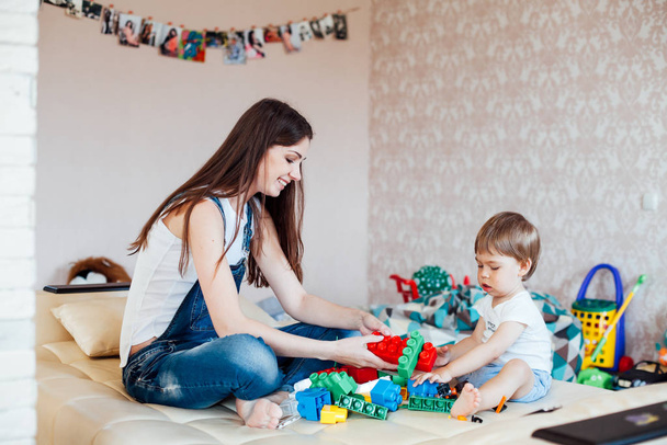 mother and little boy play with toys in the nursery - Foto, Imagen