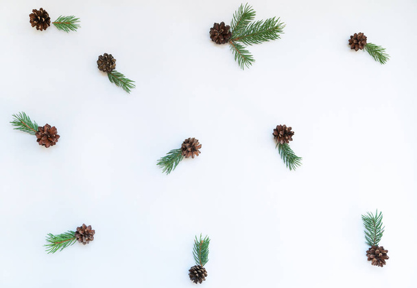 Collection of Christmas objects viewed from above. Creative minimal Christmas art. Pattern made with spruce branches and pine cone on pastel background. Flat lay. Minimal composition. - Foto, imagen